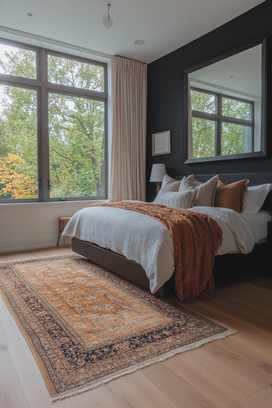 Black bedroom with a large mirror opposite a window