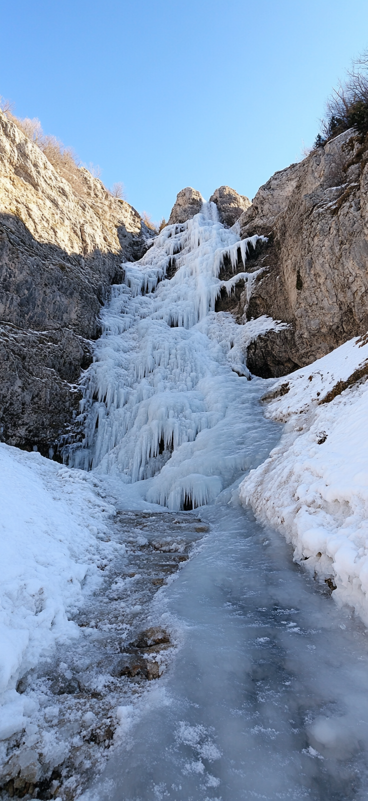 snow-covered rocks around frozen waterfall