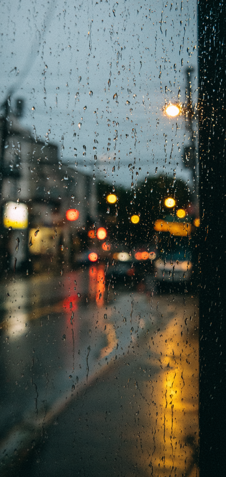 Close-up raindrops on glass with bokeh lights